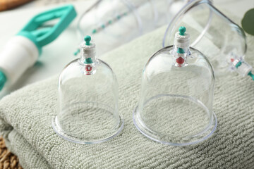 Cupping therapy. Plastic cups on soft towel, closeup