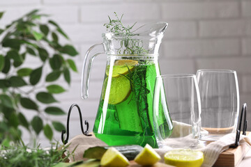Jug of homemade refreshing tarragon drink and glasses on table