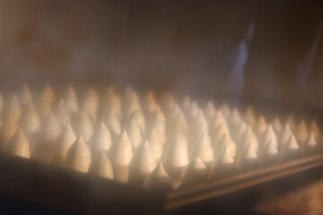 パティシエがデコレーション用にオーブンで焼いた大量のメレンゲ菓子、クリーム