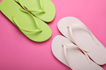 Stylish white and light green flip flops on pink background, flat lay