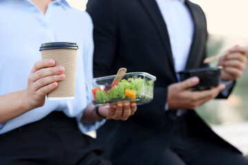Business people having lunch together outdoors, closeup