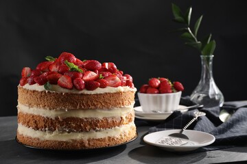 Tasty cake with fresh strawberries and mint served on gray table