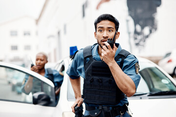 Asian man, police and walkie talkie for suspect in city communication, reinforcement or emergency. Serious male person, security guard or cop radio calling backup for crime in street of an urban town - obrazy, fototapety, plakaty