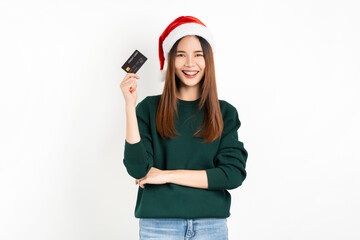 Naklejka premium Cheerful beautiful Asian woman wearing red Christmas hat and hand holding credit card on white background.
