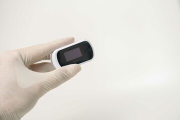 Close up of human finger while using Pulse Oximetry isolated on white background.
