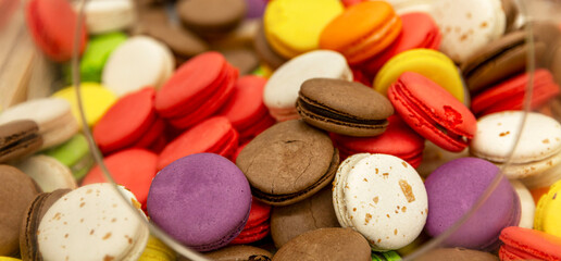 Lots of colorful macaroons on the counter in a store. Delicious sweet cookies for coffee. Close-up.