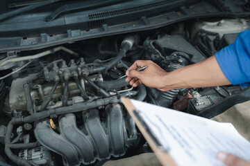 The mechanic is repairing the engine, A car repair worker is inspecting a car, A car mechanic is looking at what is the problem with the engine in the garage.