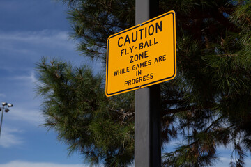 Caution sign- fly ball warning outside baseball field
