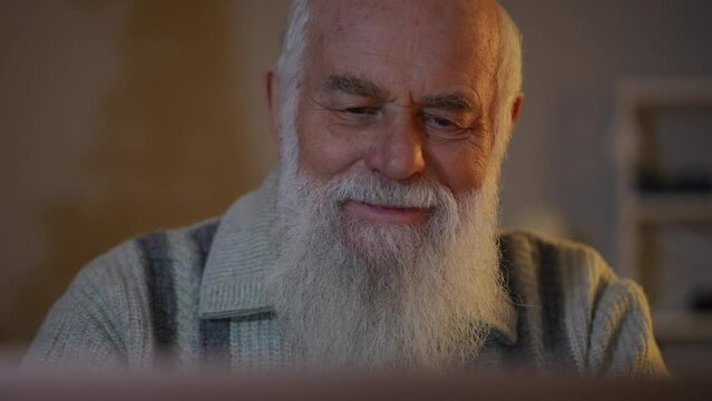 Close-up: an elderly bearded man with positive emotions on his face