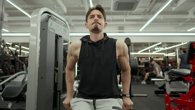 Muscular Senior Man with Beard Train Lower Chest in Dips Machine - low angle
