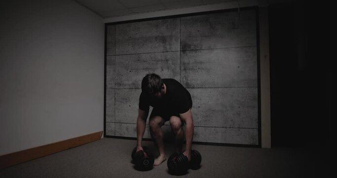 Dumbbell bent over row, cinematic lighting, white man dressed in black gym attire.