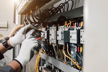 Electrician engineer tests electrical installations and wires on relay protection system.