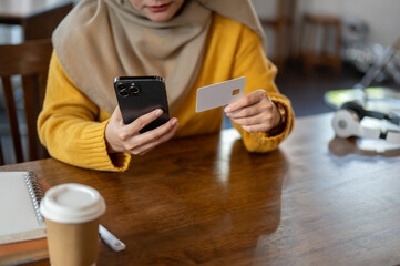 A Muslim woman using her mobile banking or registering her credit card with an shopping platform.