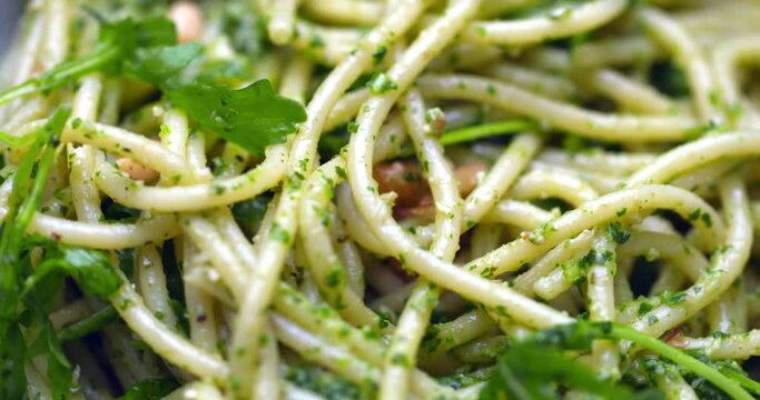 Rocket and basil spaghetti pesto. 4K image of healthy plant-based spaghetti being cooked. Tasty vegan food.