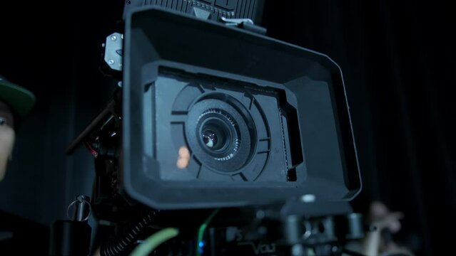 Professional digital cinema camera with set of light hanging in studio background. Close up