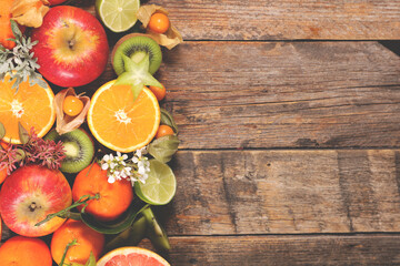 Different citrus fruit on wood background