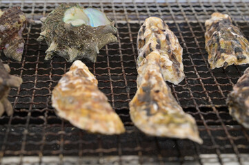 牡蠣小屋で焼き牡蠣とサザエの壺焼きを焼いているシーン