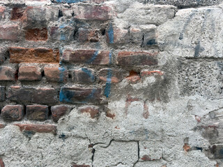 Close up detail background of an urban wall made of brown brick stones with cement mortar that sprayed by anonymous persons.