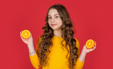 cheerful teen girl hold orange fruit on purple background