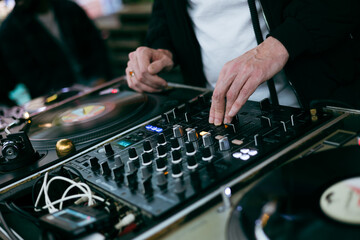 dj working at the club, mixing music with classic black disc and professional turntable
