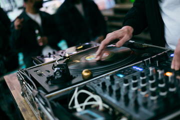 dj working at the club, mixing music with classic black disc and professional turntable