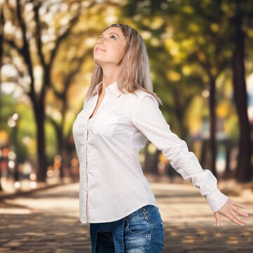 Happy young woman breathing air in a park, AI generated image