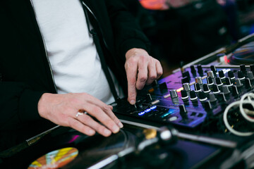 dj mixing music in a bar at night, lighting, close-up of hands