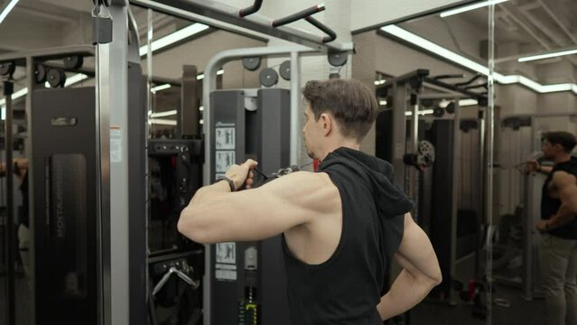 Rear Deltoid Cable Fly. Medium Shot of Sportsman Working Out Doing Shoulder Exercises