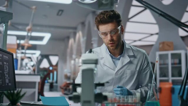 Scientist putting safety glasses working with samples in laboratory close up.
