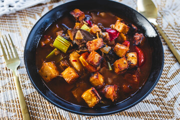 plant-based hot pot with tofu and aubergine and mixed vegetables in spicy broth