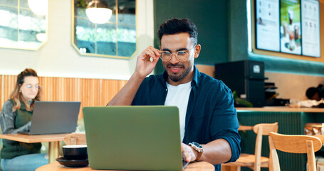 Man, reading glasses and laptop at cafe for online research, remote work and review of blog or...
