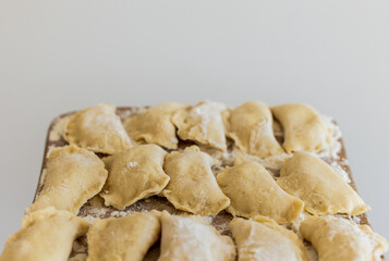 Raw dumpling. Preparation dumplings on a wooden board.