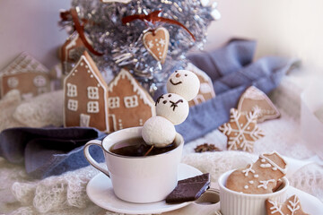Winter aesthetic morning. Marshmallow snowman in hot chocolate, ginger cookies near Christmas tree....
