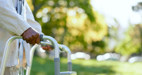 Hands, walking frame and an elderly person in a garden outdoor in summer closeup during retirement. Wellness, rehabilitation or recovery and a senior adult with a disability in the park for peace