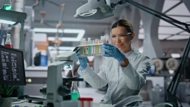 Specialist examining test tubes in laboratory close up. Woman scientist working