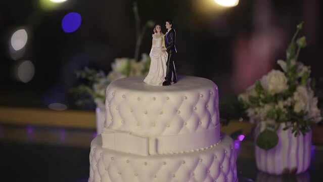 Elegant wedding cake with couple topper and bokeh background