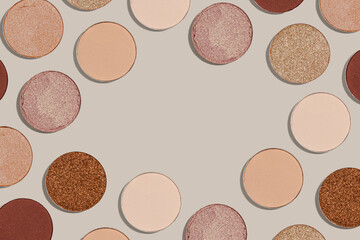 Frame with eye shadow beige brown natural color on neutral background with copyspace. Shiny and matte swatches of eyeshadows powder for make up, minimal style photo pastel colored, above view