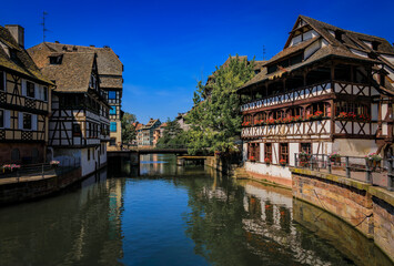 Ornate traditional half timbered houses with blooming flowers along the canals in the picturesque Petite France district of Strasbourg, Alsace, France	