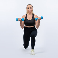 Fototapeta na wymiar Full body length shot active and sporty senior woman lifting dumbbell during weight training workout on isolated background. Healthy active physique and body care lifestyle for pensioner. Clout