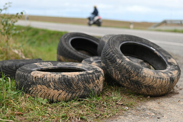 Umweltverschmutzung, illegal entsorgte Autoreifen an einer Landstraße