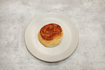 A bisquet on a plate. One of the popular Mexican sweet breads (pan dulce Mexicano).