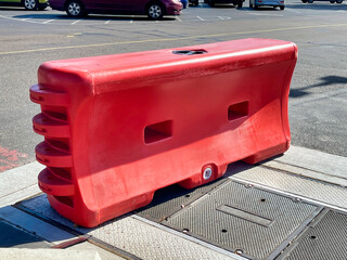 A polyethylene portable divider or barrier fillable with sand or water tor heavier or extended use.