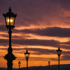 Obraz premium Hills and street lamps under a cloudy sky during a beautiful sunset