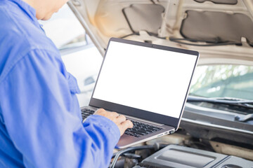 Auto mechanic working on laptop at mechanic shop, technician diagnosing car engine with a laptop with special program