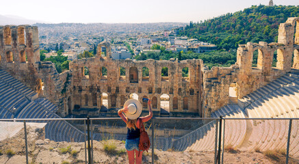 Woman tourist taking picture with smartphone atTheatre of Herodion Atticus, Athens, Greece