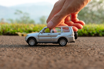 Concept for outdoor activities with toy for children. Photo of a toy car held by hand. After some edits. - obrazy, fototapety, plakaty