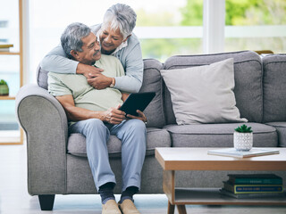 Tablet, couple and hug on sofa in home living room for love, care and quality time. Senior man, happy woman and embrace with digital technology for online shopping, social media and scroll internet