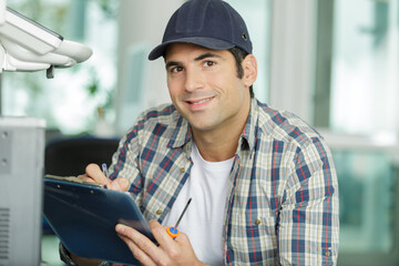 happy technician working on photocopier