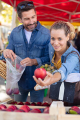 portrait of couple buying fruits at local market