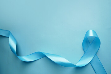 Blue awareness ribbon with the trail on a  blue background with copy space. Prostate Cancer Awareness, child abuse, diabetes. 
